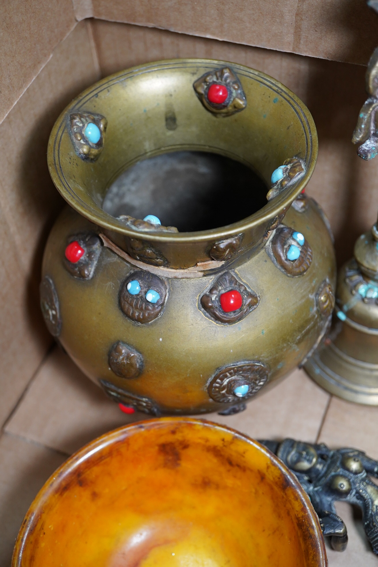 A group of Tibetan brass and mixed metal artefacts to include a brass vase with cabochon inset stones and figures of deities, largest 22cm high. Condition - mostly fair